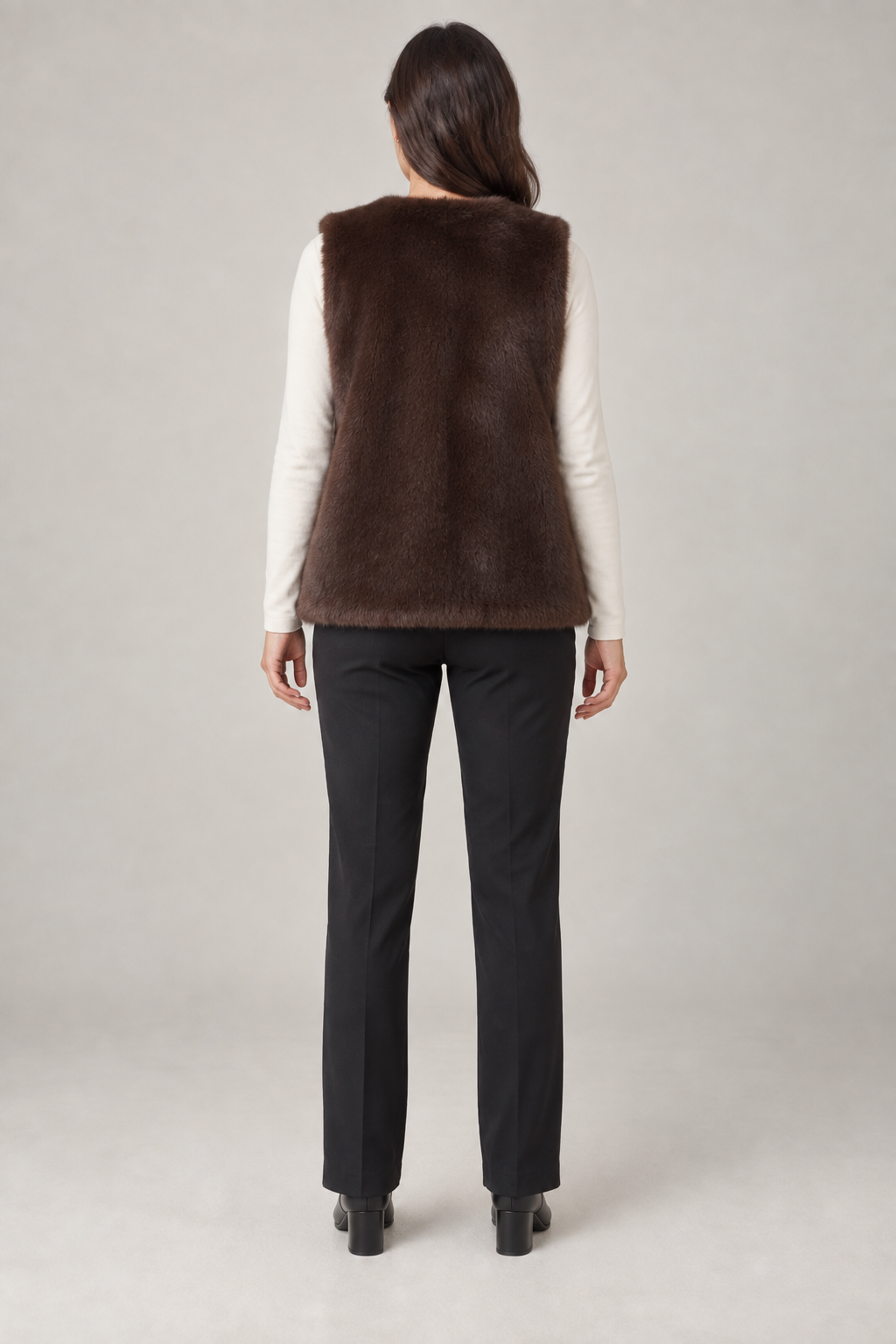 Back view of a cocoa faux fur vest design on a woman