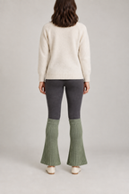 Back design preview of sage flared leg warmers worn over dark leggings.