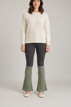 Front design preview of sage flared leg warmers worn over dark leggings.