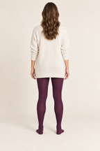 Back design preview of plum adult footed tights styled with a cream tunic.
