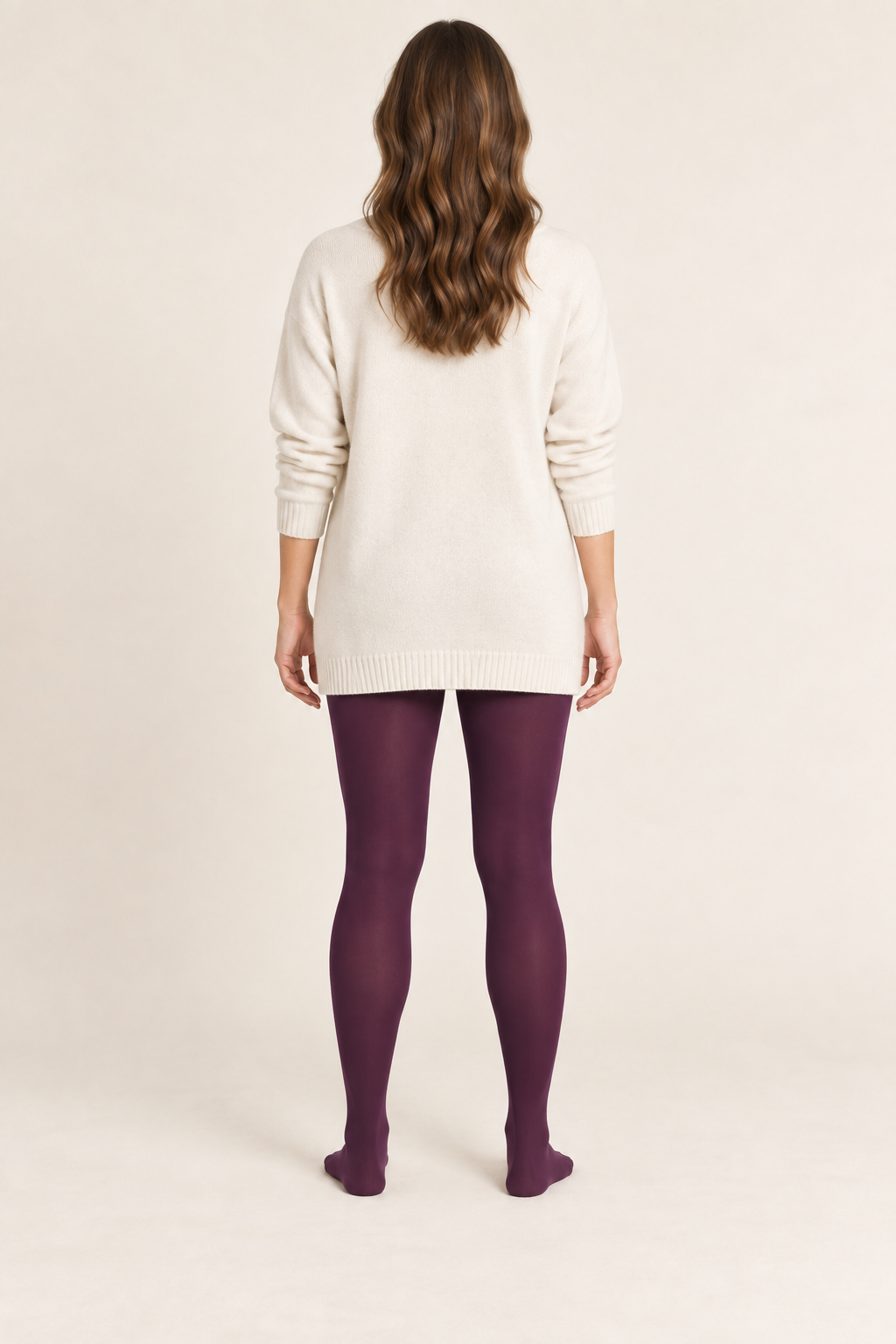 Back design preview of plum adult footed tights styled with a cream tunic.