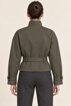 AI preview: back of the olive-grey cropped trench with a center seam, belt loops, dropped shoulders and plain upper-hip hem.