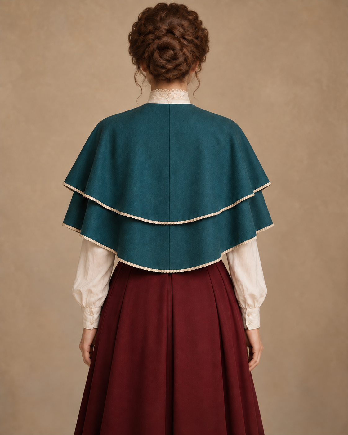 Back view of the short double-tier cape with a center-back seam and ivory hem trim