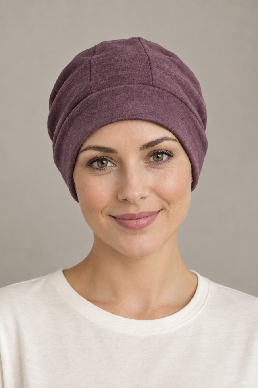 Front design preview of mauve soft jersey cap with shaped crown panels and a broad band, worn with a white shirt.