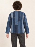 Back view of a collarless upcycled denim jacket showing the flat modular panel assembly; generated design preview.