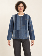 Front view of a woman wearing a collarless zip jacket assembled from blue reclaimed-denim panels; generated design preview.