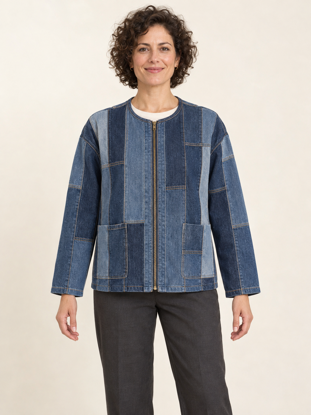 Front view of a woman wearing a collarless zip jacket assembled from blue reclaimed-denim panels; generated design preview.