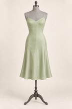 AI front preview of a pistachio slip with diagonal French darts, narrow straps and a softly flared gored skirt