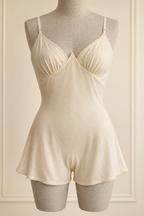 AI preview: ivory bias-cut teddy with narrow straps, pointed bust join and flared divided legs.
