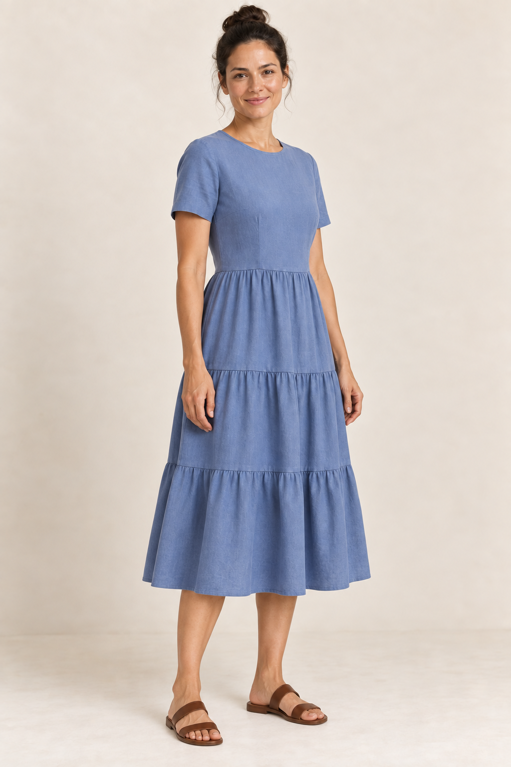 AI design preview: three-quarter view of the blue short-sleeve dress showing its gently shaped bodice, joined gathered tiers and calf-length hem