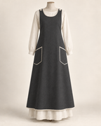 AI concept illustration of 1916 shoulder-button cross-back apron, front view in alternative charcoal, on a mannequin.