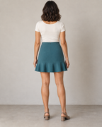 Rear design preview of the petrol flounce-hem mini skirt, with a concealed center-back zipper and an uninterrupted flared hem