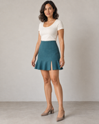 Three-quarter design preview of the petrol mini skirt, showing its smooth fitted body, short front slit and single flared hem