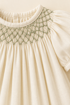 AI concept close-up of sage honeycomb smocking, neckline pleats and ivory cotton fabric