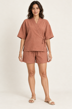 AI design preview: adult woman in terracotta Jinbei-inspired crossover top and drawstring shorts, front view with compact left-side tie