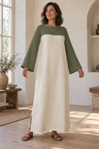 Adult woman wearing a sage and ivory caftan with curved yoke continuing into long sleeves