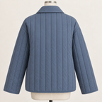 AI design preview: slate-blue quilted jacket back with plain vertical-channel body, lowered turnover collar and loose long sleeves