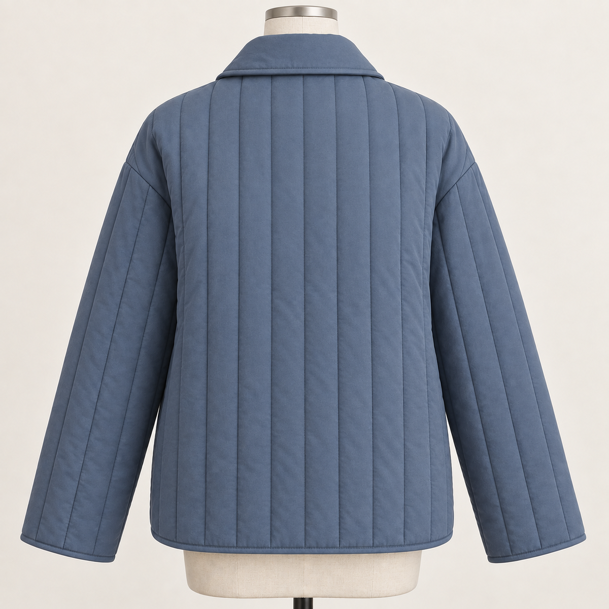AI design preview: slate-blue quilted jacket back with plain vertical-channel body, lowered turnover collar and loose long sleeves